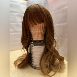 Full coverage med brown wig with bangs and highlights.